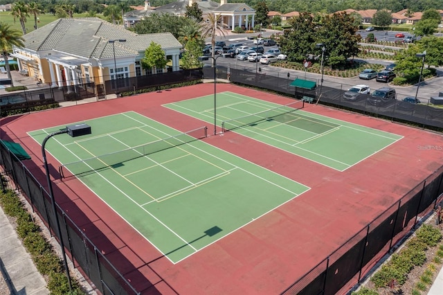 view of tennis court with community basketball court and fence