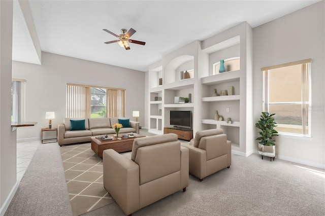 living room with built in shelves, ceiling fan, and light colored carpet