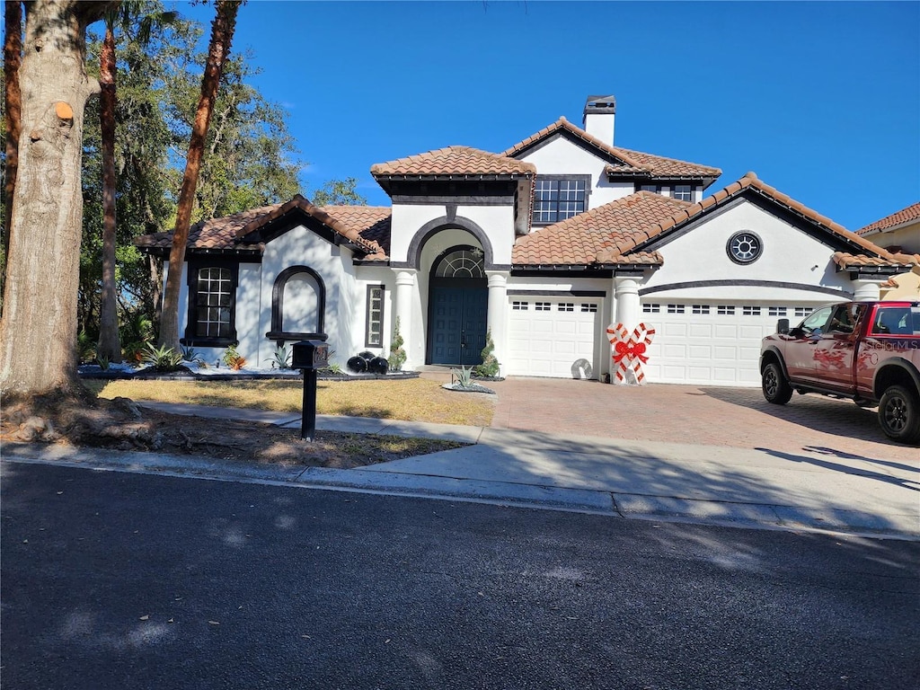 mediterranean / spanish-style home with a garage