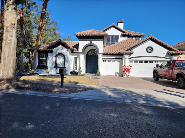 mediterranean / spanish-style home with a garage