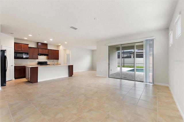 kitchen featuring sink, an island with sink, black appliances, and light tile patterned floors