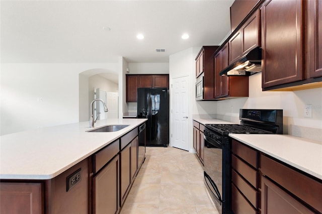 kitchen featuring dark brown cabinets, sink, a kitchen island with sink, and black appliances