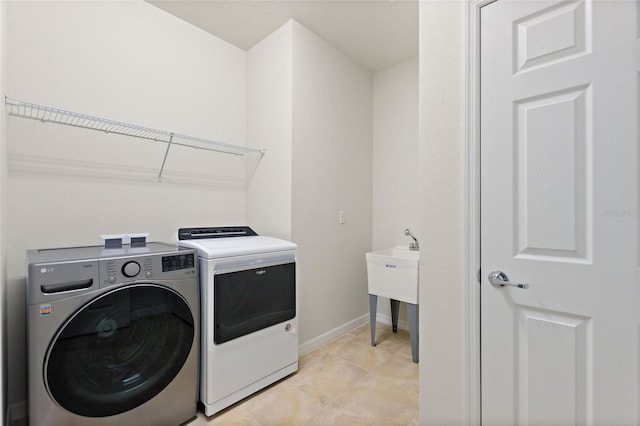 clothes washing area featuring washing machine and clothes dryer and light tile patterned flooring