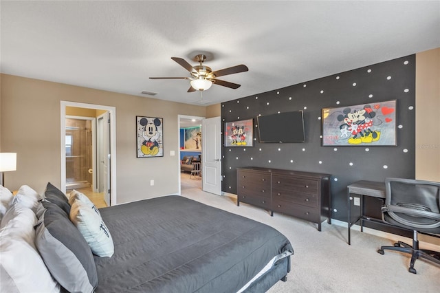 carpeted bedroom featuring ceiling fan and ensuite bath