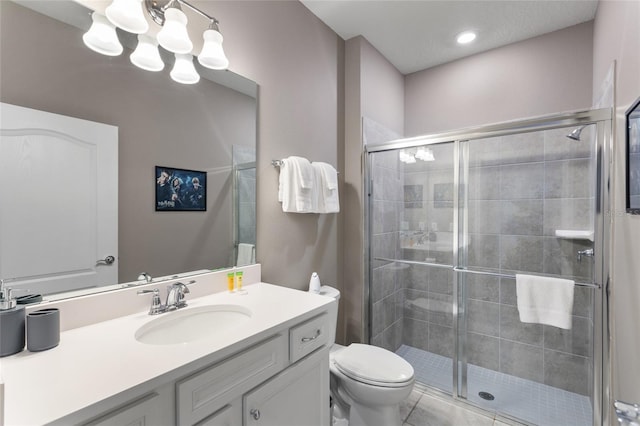 bathroom with vanity, a shower with shower door, and toilet