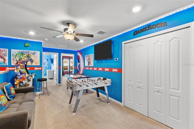 rec room featuring ceiling fan, light colored carpet, and a textured ceiling