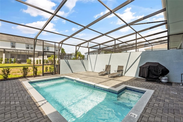 view of swimming pool featuring a patio and glass enclosure