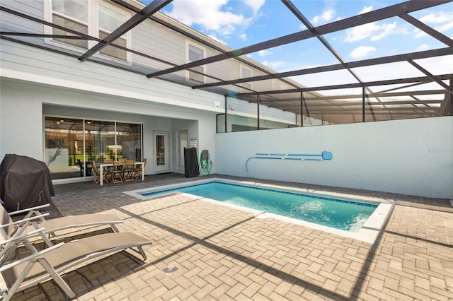 view of swimming pool with a lanai, a patio, and a grill