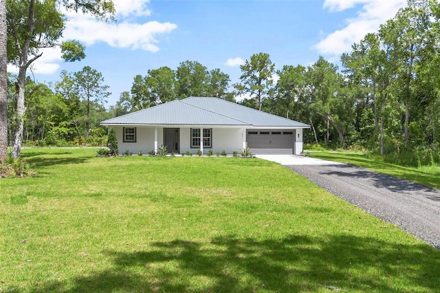 ranch-style home featuring stucco siding, an attached garage, a front yard, metal roof, and driveway