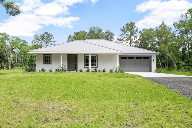 ranch-style home featuring a garage, a front yard, metal roof, and driveway