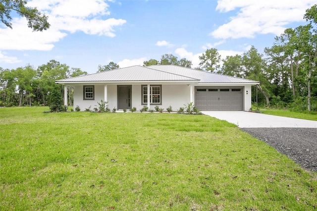 ranch-style house with driveway, a garage, metal roof, a front yard, and stucco siding