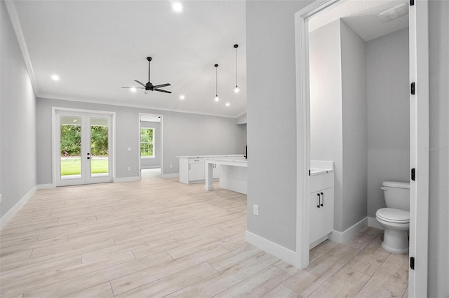 bathroom featuring toilet, wood finished floors, vanity, baseboards, and french doors