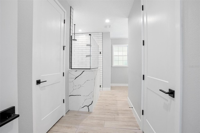 hall with wood finish floors, visible vents, baseboards, and recessed lighting