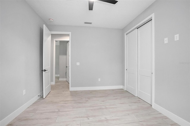 unfurnished bedroom with light wood-style floors, a closet, visible vents, and baseboards