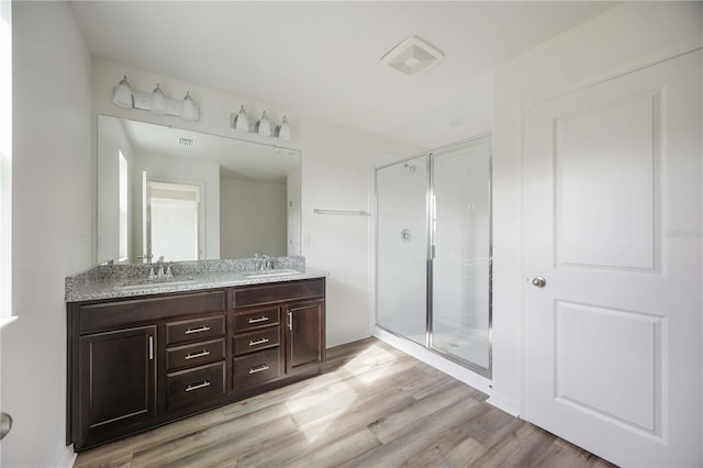 bathroom featuring walk in shower, wood-type flooring, and vanity