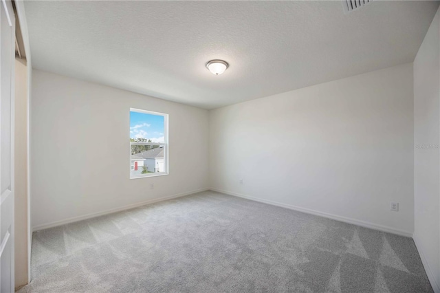 carpeted spare room featuring a textured ceiling