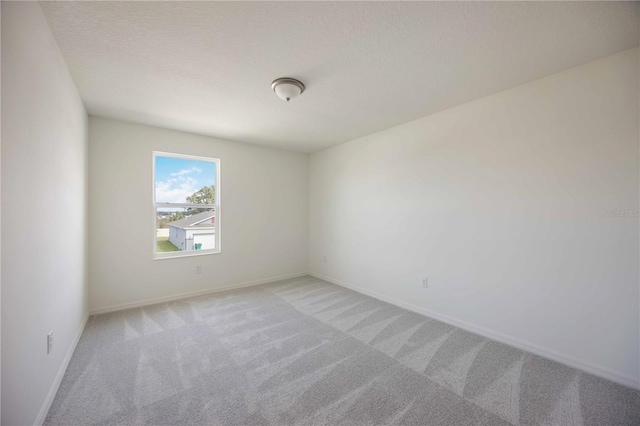 carpeted empty room with a textured ceiling