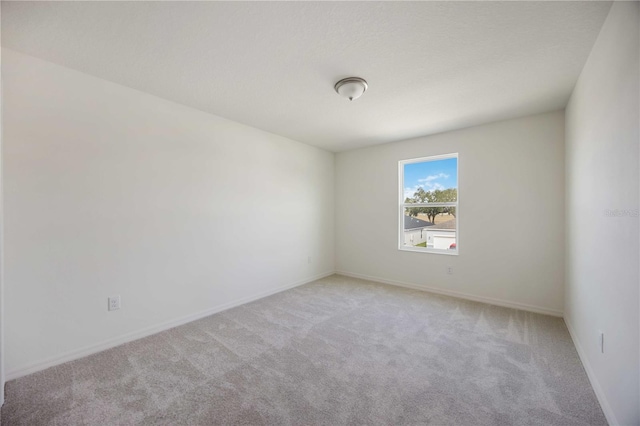 spare room featuring light colored carpet