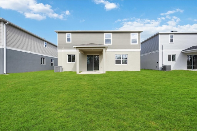 rear view of property with cooling unit and a yard