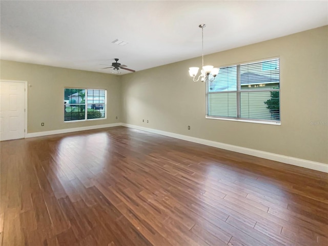 spare room with dark hardwood / wood-style floors and ceiling fan with notable chandelier