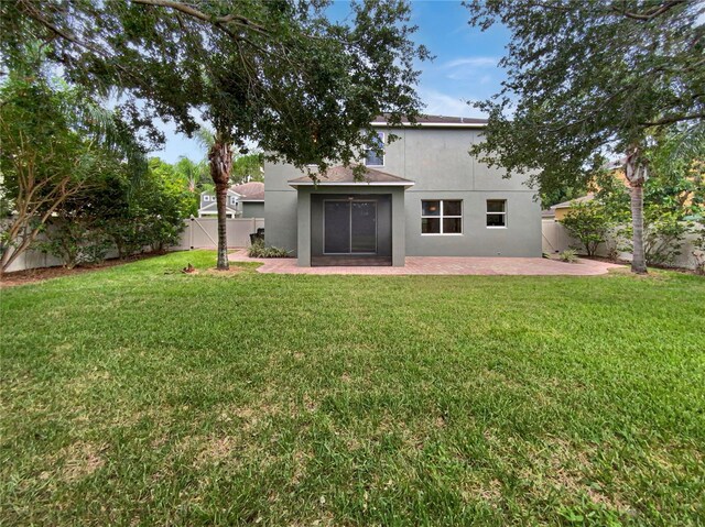 rear view of house with a patio and a yard