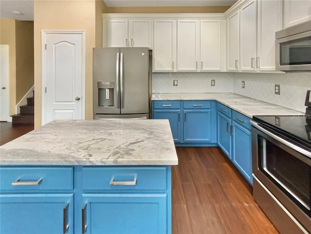 kitchen featuring blue cabinetry, appliances with stainless steel finishes, backsplash, and dark hardwood / wood-style floors