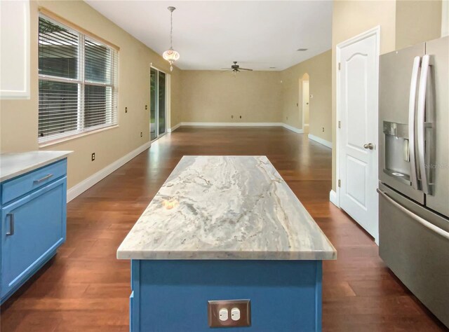 kitchen featuring a center island, blue cabinetry, stainless steel fridge, and dark hardwood / wood-style flooring