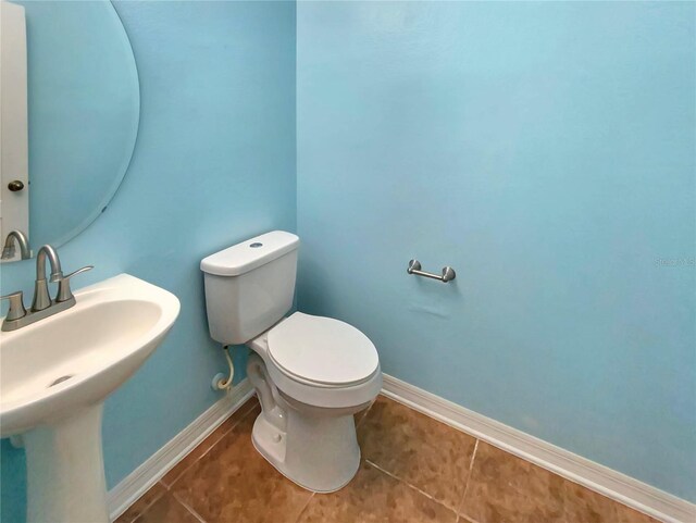 bathroom featuring tile flooring, sink, and toilet