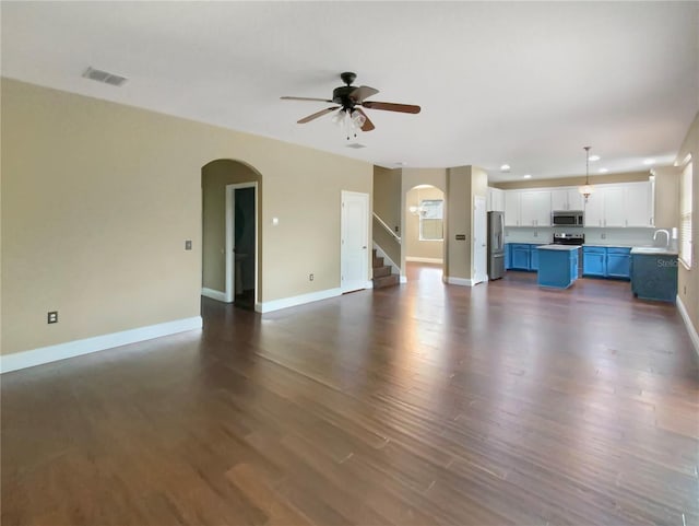 unfurnished living room with sink, ceiling fan, and dark hardwood / wood-style flooring