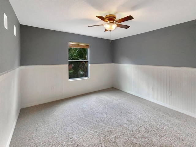 spare room with ceiling fan and light colored carpet