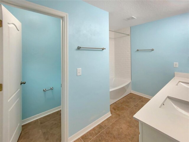 bathroom featuring a textured ceiling, double sink vanity, shower / washtub combination, and tile floors