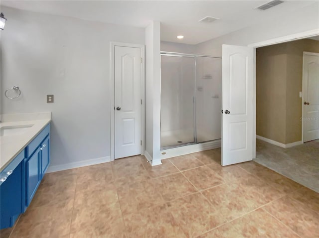 bathroom featuring tile floors, a shower with door, and vanity