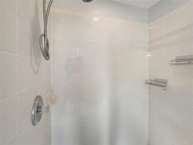 interior details featuring a tile shower