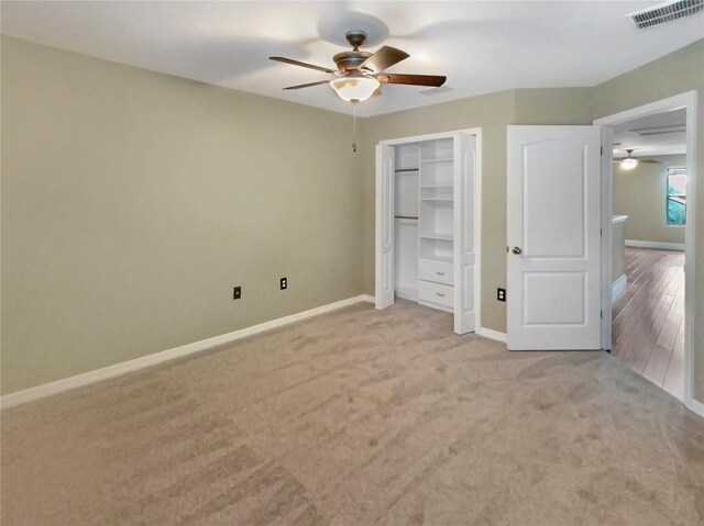 unfurnished bedroom with carpet, a closet, and ceiling fan