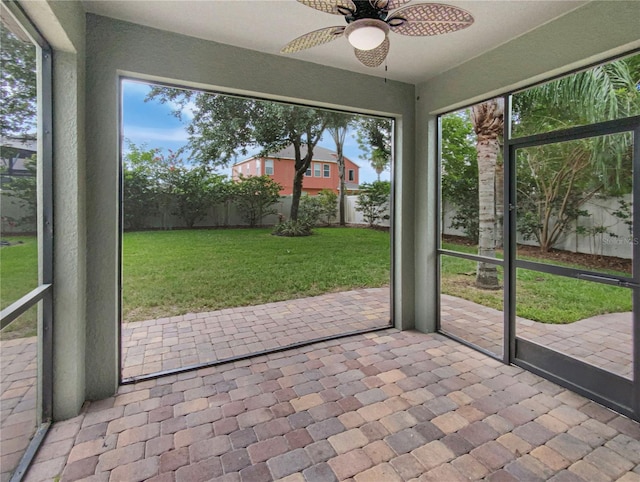 unfurnished sunroom with ceiling fan