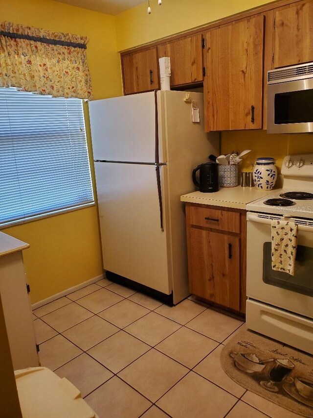 kitchen with light tile patterned flooring and white appliances