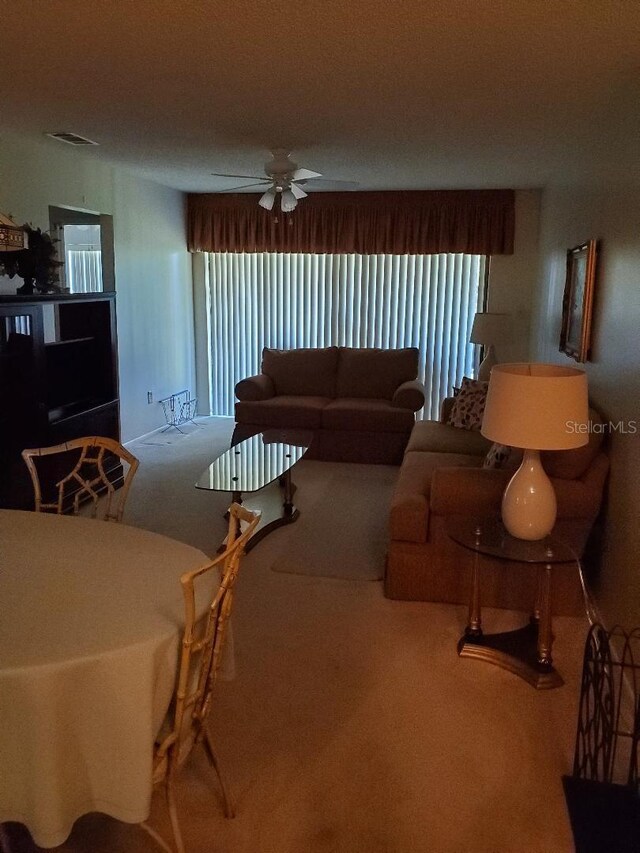 carpeted living room with ceiling fan