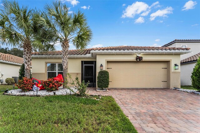 mediterranean / spanish house with a garage and a front yard