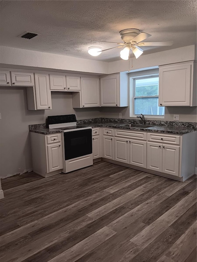 kitchen featuring dark wood-type flooring, sink, white cabinetry, a textured ceiling, and electric stove