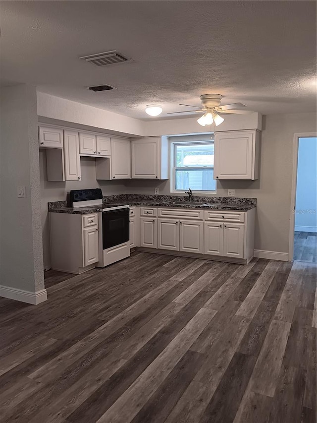 kitchen with electric range oven, sink, white cabinets, and dark hardwood / wood-style floors