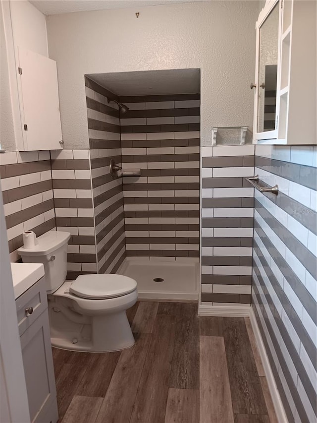 bathroom with walk in shower, wood-type flooring, toilet, and vanity