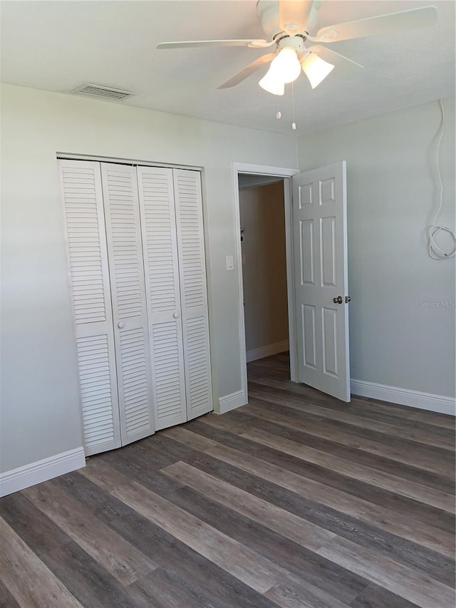 unfurnished bedroom featuring dark hardwood / wood-style flooring, a closet, and ceiling fan