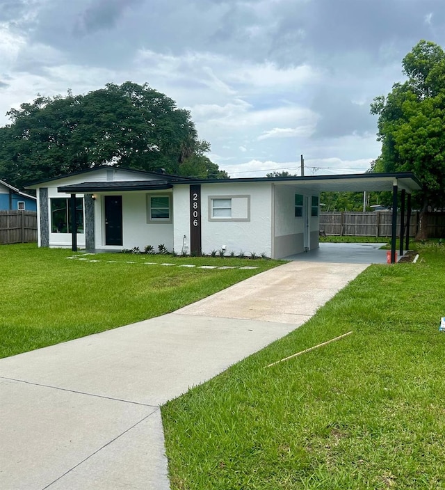 view of front of house featuring a carport and a front lawn