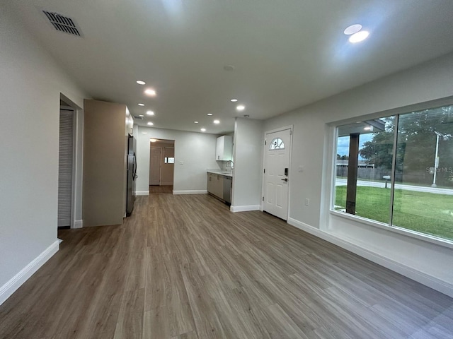 unfurnished living room with light wood-type flooring and sink