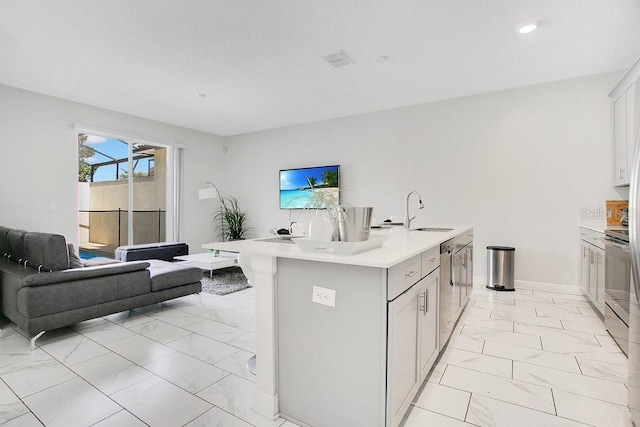 kitchen featuring white cabinets, dishwasher, a kitchen island with sink, and sink