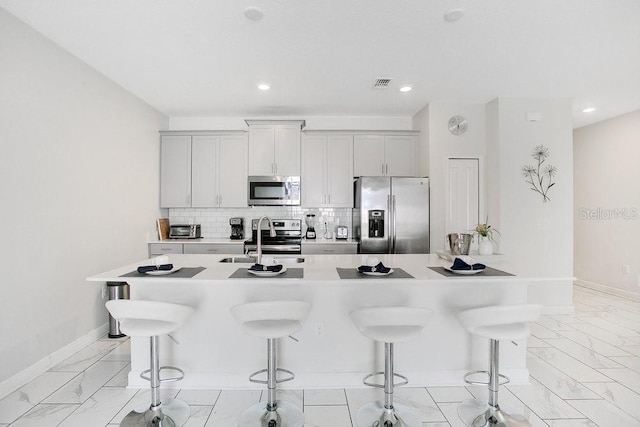 kitchen with appliances with stainless steel finishes, sink, and a breakfast bar