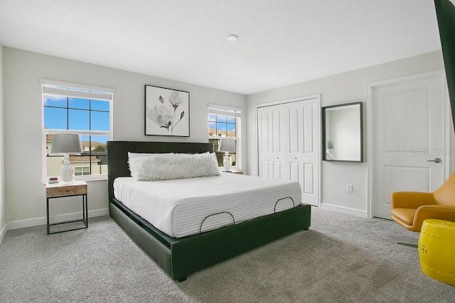 bedroom with multiple windows, a closet, and carpet floors