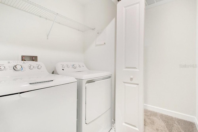 laundry area with separate washer and dryer and light colored carpet