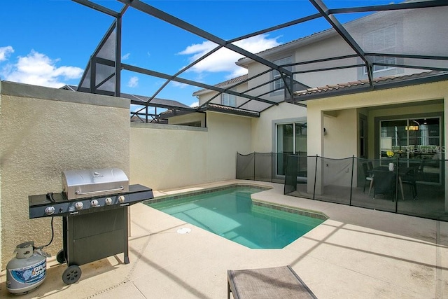 view of pool with glass enclosure, area for grilling, and a patio area