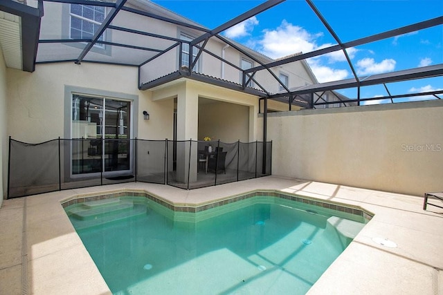 view of swimming pool with glass enclosure and a patio area